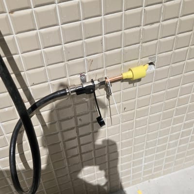 צינור גז מחובר לשסתום על קיר אריחים