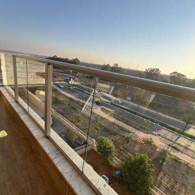 מרפסת עם מעקה זכוכית ונוף לעיר