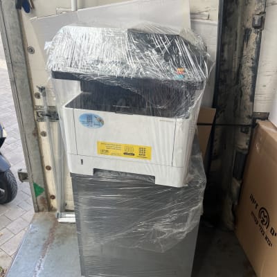 מדפסת עטופה בניילון על עגלה עם גלגלים