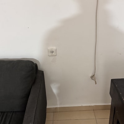 שקע חשמל על קיר עם כבל חשוף