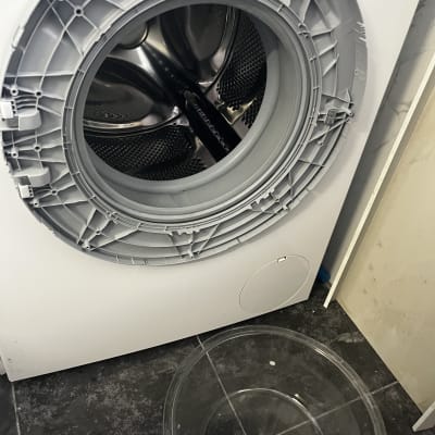 מכונת כביסה פתוחה עם קערה על הרצפה