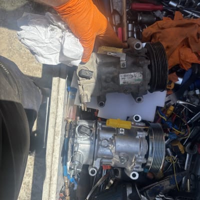 יד עם כפפה כתומה מחזיקה חלק חשמלי לרכב