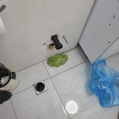 צינור פתוח על קיר, רצפה רטובה, כלי עבודה