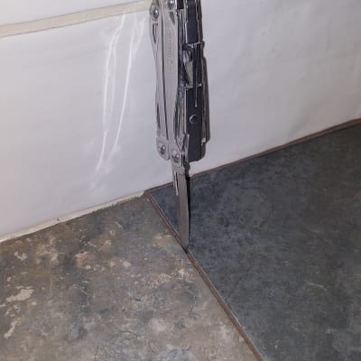 סכין מולטיטול תקוע בין אריחי רצפה וקיר