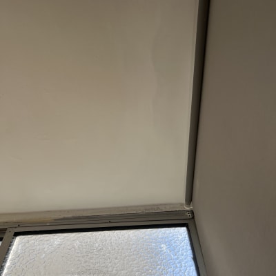 קיר צבוע ליד חלון עם זכוכית מחוספסת