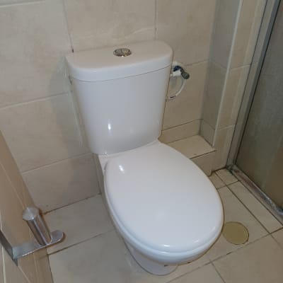 אסלה לבנה עם צינור מים מחובר