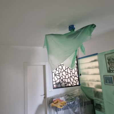 חדר עם כיסוי פלסטיק על רהיטים ותקרה צבועה