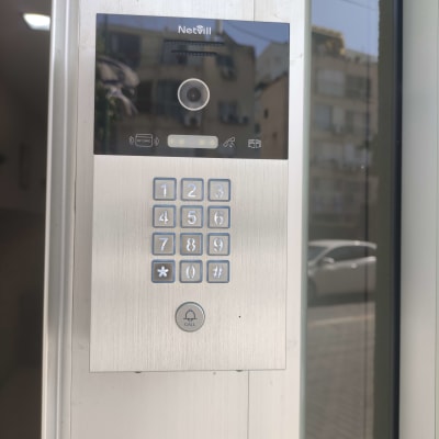 אינטרקום עם מצלמה ומקשים על קיר חיצוני