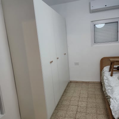 ארון בגדים לבן בחדר שינה עם מיטה