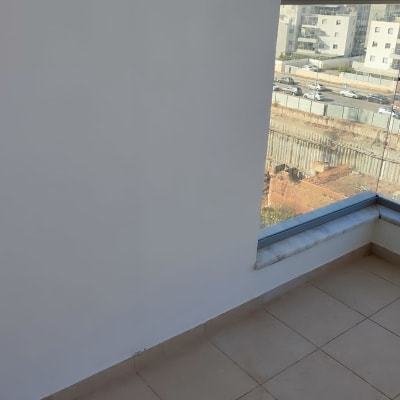 קיר צבוע ולידו חלון גדול עם נוף עירוני