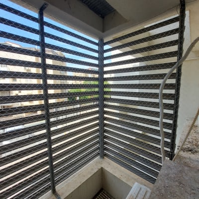 רשת מתכת על חלון למניעת כניסת יונים