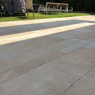 רצפת אבן חיצונית עם כיסאות ושולחן בגינה