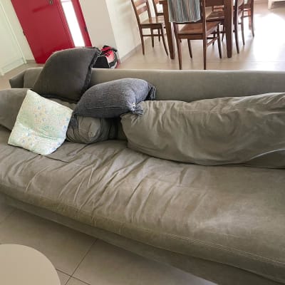 ספה אפורה עם כריות בסלון מואר