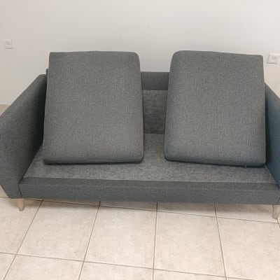 ספה אפורה עם כריות על רצפת אריחים