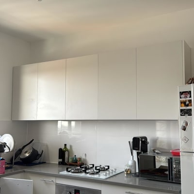 מטבח מודרני עם ארונות לבנים ותנור בילט אין