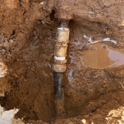 צינור מים עם חיבור מתכת באדמה רטובה
