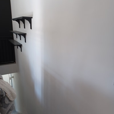 מדפים שחורים מותקנים על קיר לבן