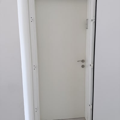 דלת לבנה עם ידית כסופה במסגרת לבנה
