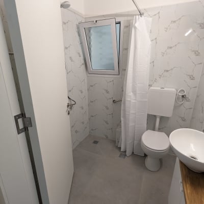 חדר אמבטיה משופץ עם אריחים חדשים ומקלחת