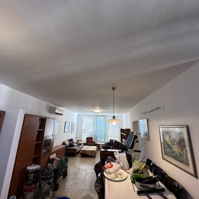 פחיות צבע ומברשות על הרצפה ליד קיר