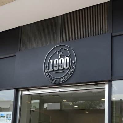 שלט חנות עם לוגו 1990 וכובע שף