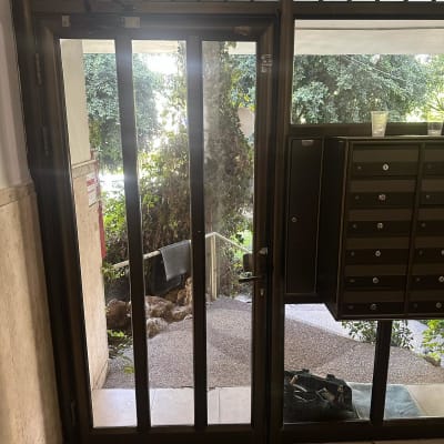 דלת זכוכית עם תיבות דואר ליד כניסה לבניין