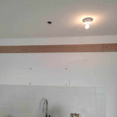 קיר גבס עם קרש עץ מחובר מעל כיור