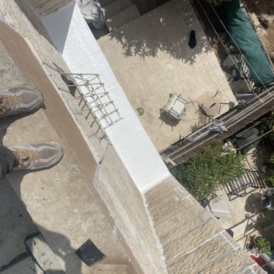 איטום גג עם חומר לבן על קיר חיצוני