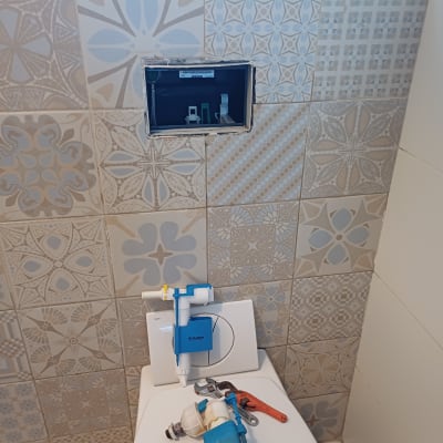 חלקי אסלה וכלי עבודה על מכסה אסלה