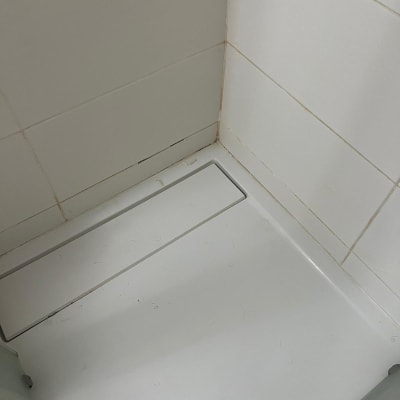 רצפת מקלחת עם אריחים לבנים וניקוז