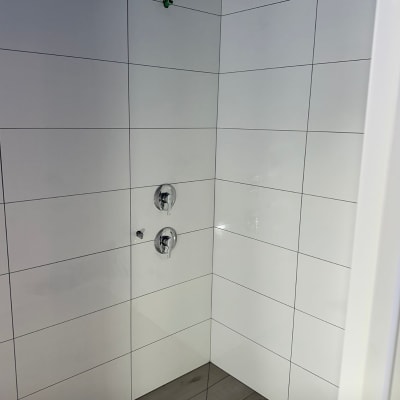 חדר אמבטיה עם אריחים חדשים וברזים מותקנים