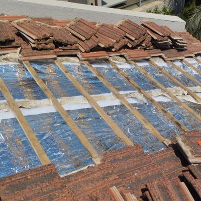 רעפים מונחים על גג עם יריעות בידוד מתחת