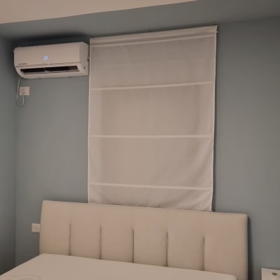 מזגן מותקן על קיר מעל מיטה