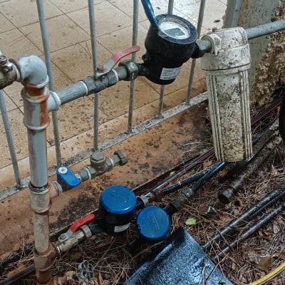 מד מים וצנרת ליד גדר מתכת