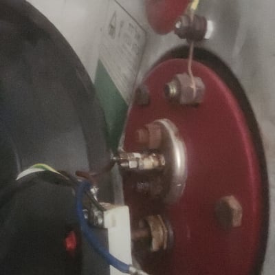 חיבורים חשמליים על לוח מתכת אדום עם חוטים