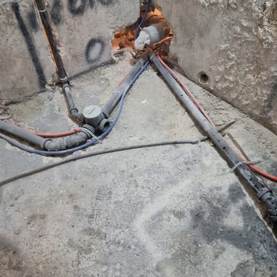 צינורות חשמל ומים מותקנים בקיר בטון חשוף