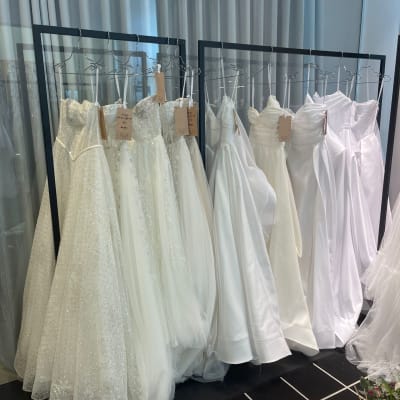 שמלות כלה תלויות על מסגרות מתכת בחנות