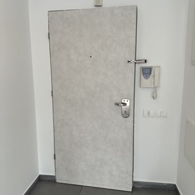 דלת עם ציפוי ומנעול, אינטרקום על הקיר