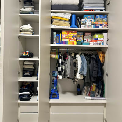 ארון בגדים מאורגן עם בגדים, משחקים ומעילים תלויים