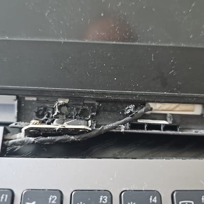 מחשב נייד עם מסך שבור וחלקים חשופים