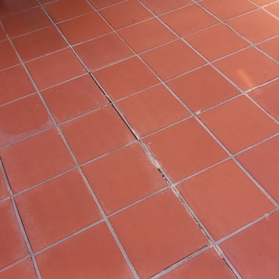 רצפת אריחים אדומים עם סימני לכלוך וניקוי