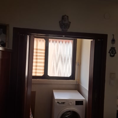 מכונת כביסה ליד חלון זכוכית עם וילון