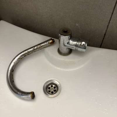 ברז שבור על כיור עם צינור מתכת חלוד