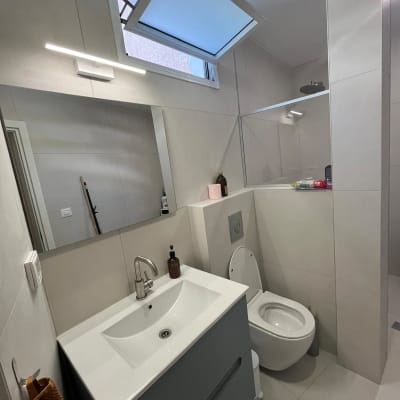 חדר אמבטיה עם כיור, מראה ושירותים מודרניים