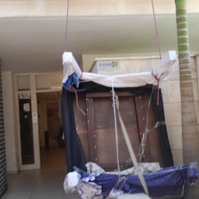 רהיט עטוף בניילון תלוי על חבלים במעבר בניין