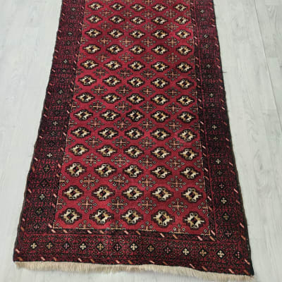 שטיח אדום עם דוגמאות גיאומטריות על רצפה בהירה