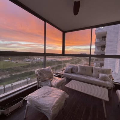 מרפסת עם ריהוט פלסטיק ונוף שקיעה