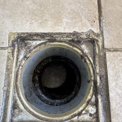 פתח ניקוז מלוכלך עם שאריות לכלוך ומים