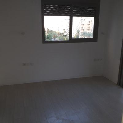 חדר ריק עם קירות לבנים ורצפת עץ