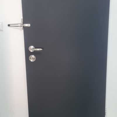 דלת מצופה בצבע כהה עם ידיות מתכת